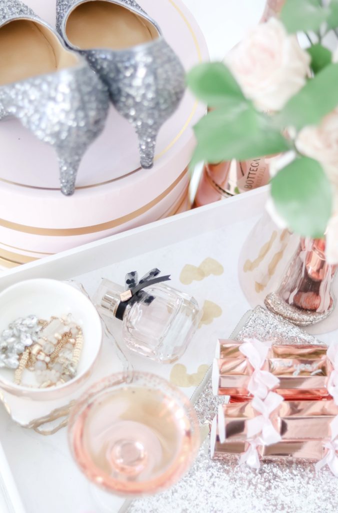 New Year's Eve styled vanity with sparkly heels, sparkling rosé , perfume and fresh roses