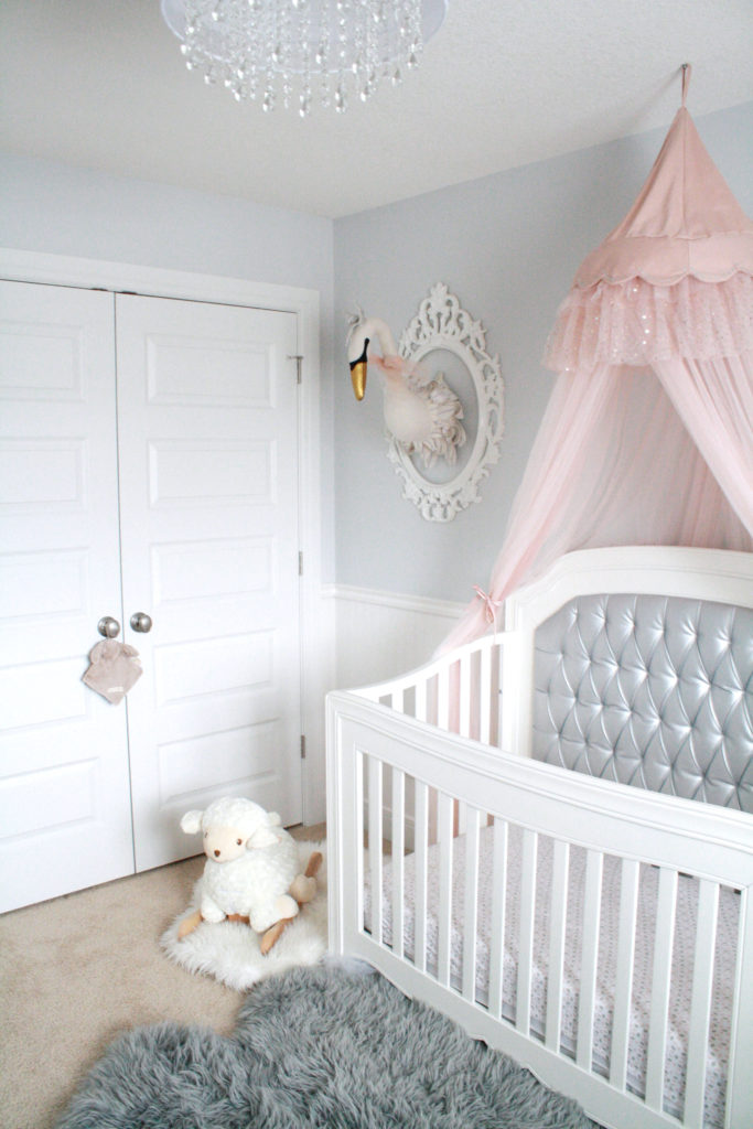 Pink and gray nursery for baby girl with silver tufted crib and pink canopy