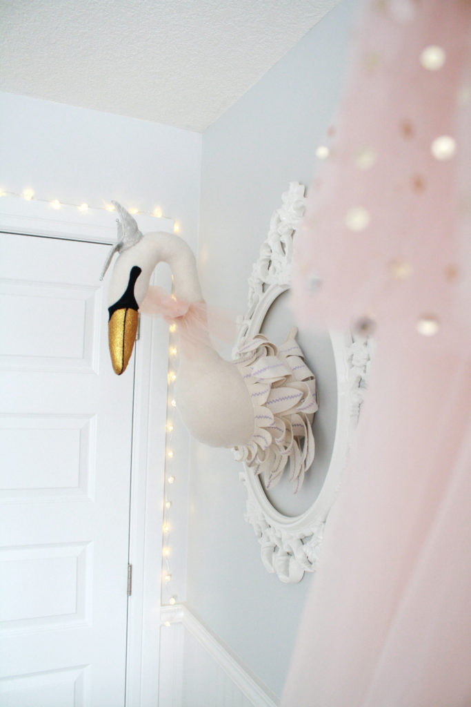 Pink and gray nursery with plush taxidermy-style swan head 