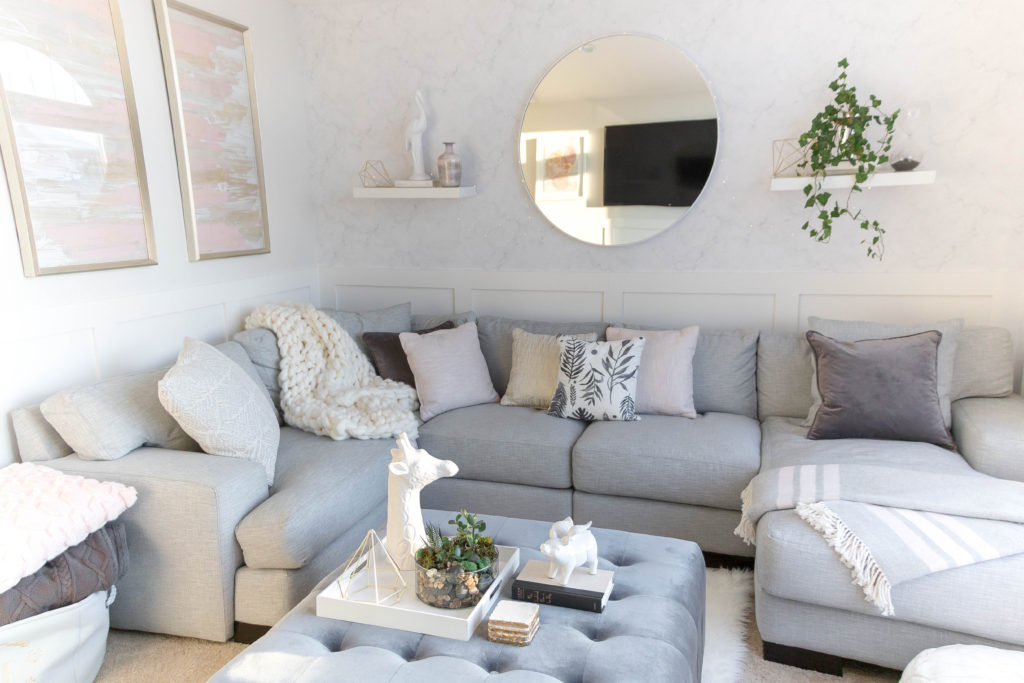 Light and bright kid-friendly living room with comfortable sectional and velvet ottoman