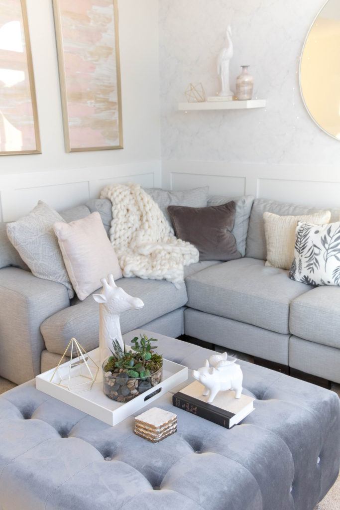 Light and bright kid-friendly living room with charcoal gray oversized velvet ottoman and sectional couch 
