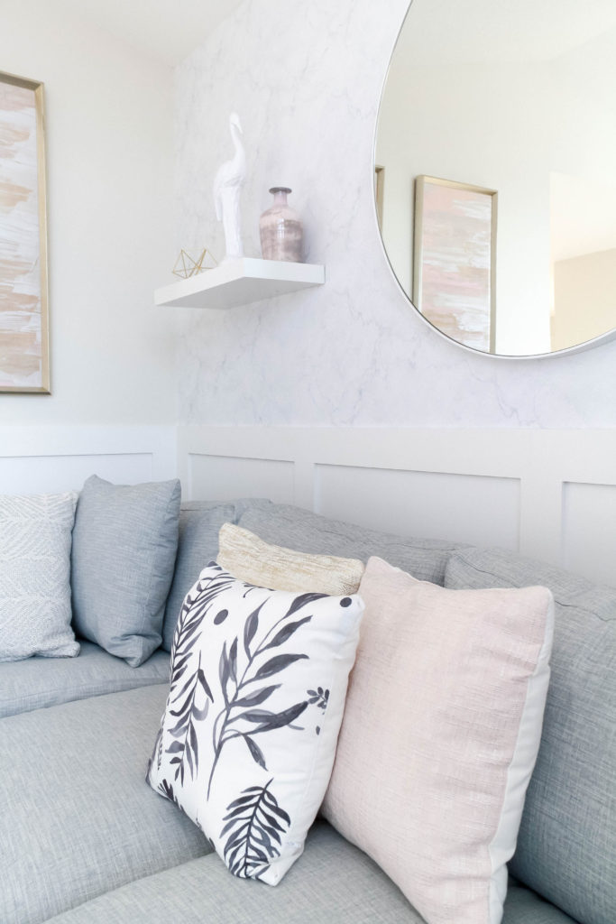 Light and bright kid-friendly living room with gray, pink, gold and palm-print pillows