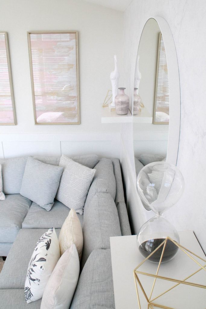 Light and bright kid-friendly living room with floating shelves. Sitting room in blush pink, gray and gold.