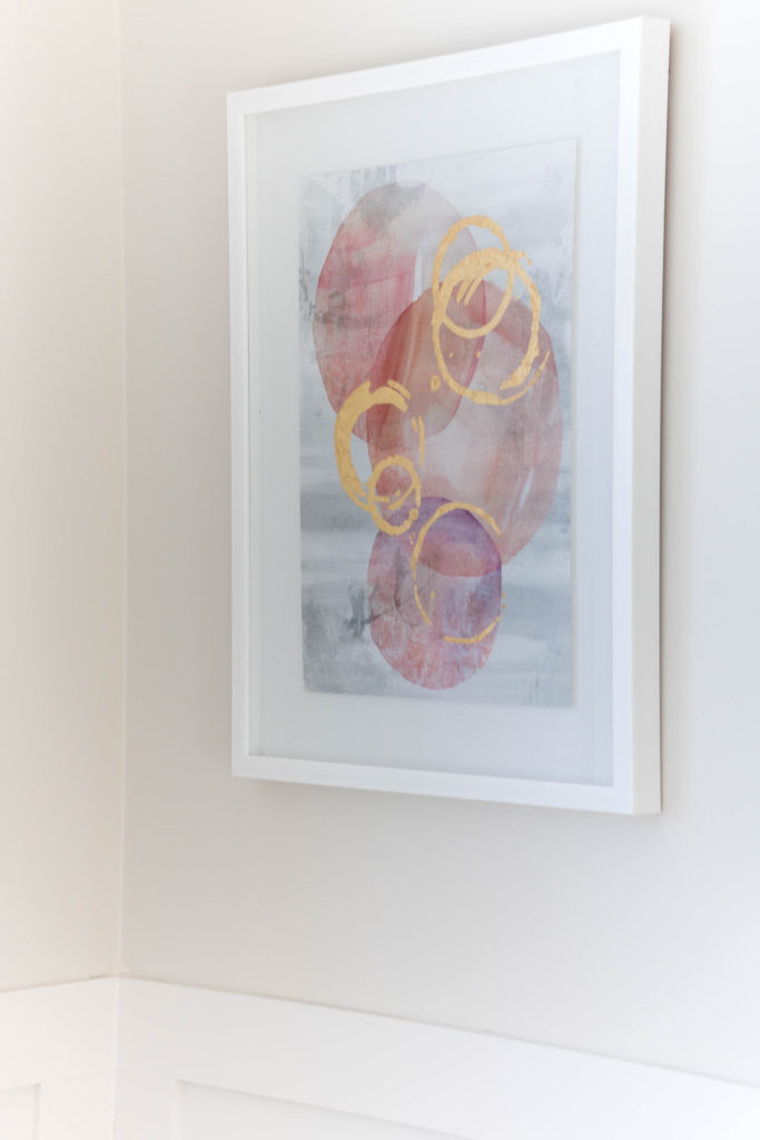 Light and bright kid-friendly living room with pink and gold abstract framed art