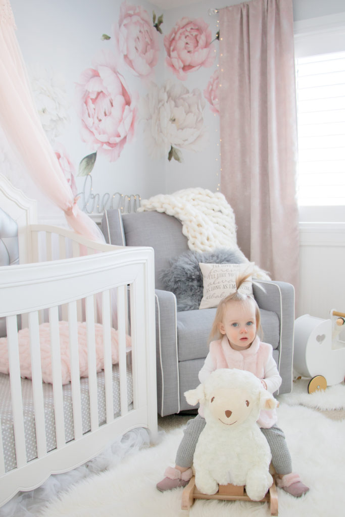 My toddler daughter enjoying her rocking lamb in her pink and white nursery with peony wall decals by Rocky Mountain Decals