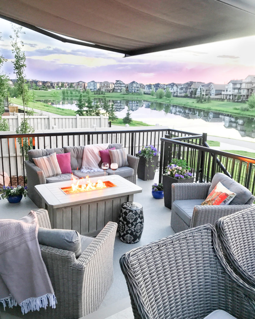 This patio with comfortable gray patio furniture and a fire table overlooking the lake is the perfect spot to enjoy a Grapefruit Rosé Sangria