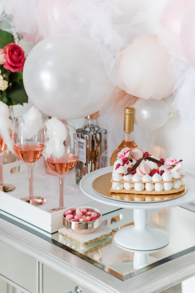 Valentine’s Day bar with heart-shaped cake, balloon garland and rose cocktails