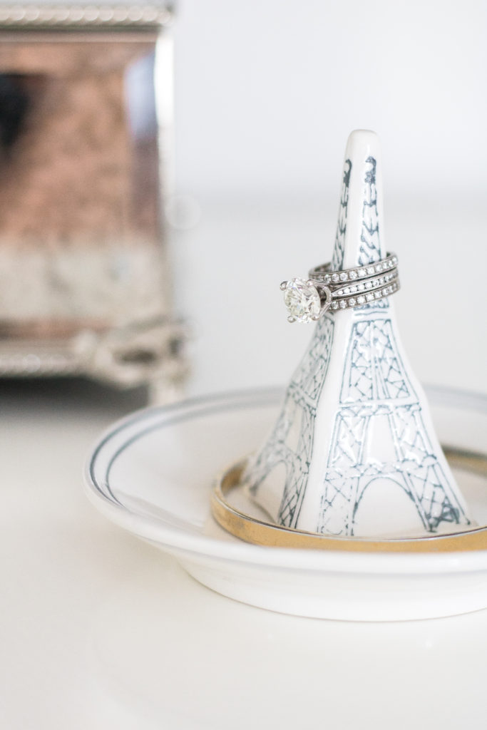 Solitaire engagement ring and diamond wedding bands on a paris eiffel tower ring dish - bright and cozy master bedroom - gray, white and pink bedroom ideas