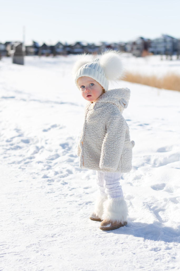 Baby girl in all-white snow gear and pom pom toque - New Year's Resolutions for 2019