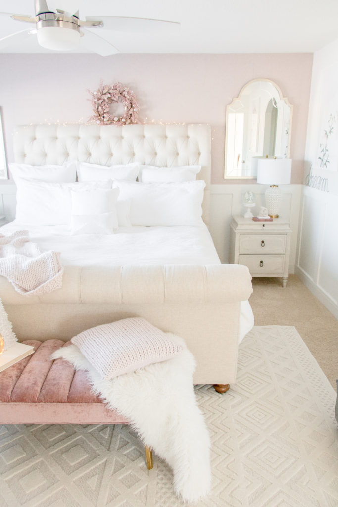 Feminine master bedroom decor: blush pink and white master bedroom with neutral furniture and textured rug
