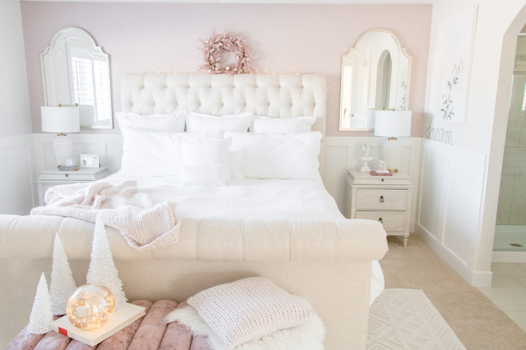 Feminine Master bedroom design ideas: Neutral luxurious master bedroom with white bedding, neutral sleigh bed, blush pink wallpaper and velvet bench 