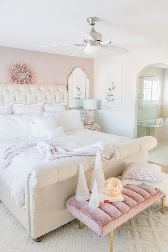Feminine Master bedroom design ideas: Neutral luxurious master bedroom with white bedding, neutral sleigh bed, blush pink wallpaper and velvet bench 