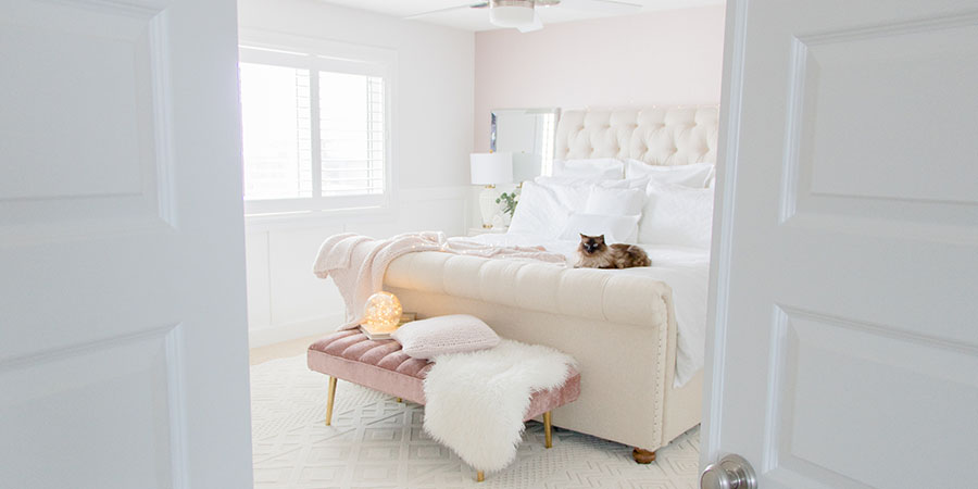 Pink, white and neutral luxurious master bedroom refresh with tufted sleigh bed and white furnishings