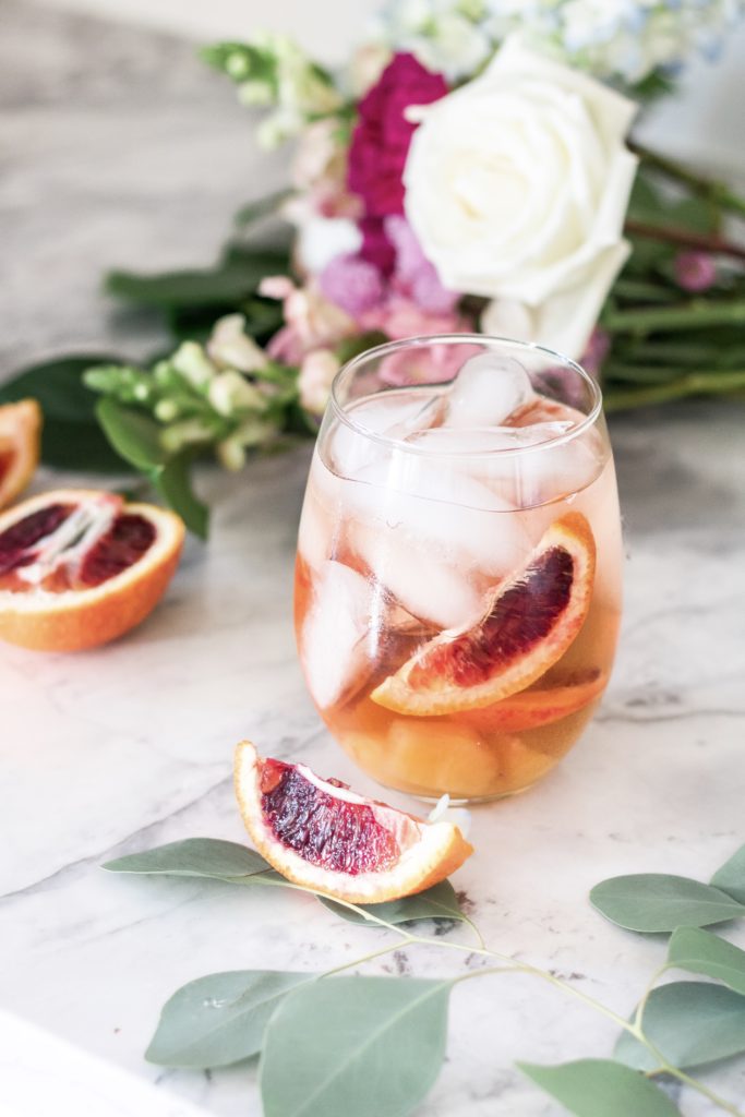 Glass of blood orange sangria with fresh flowers