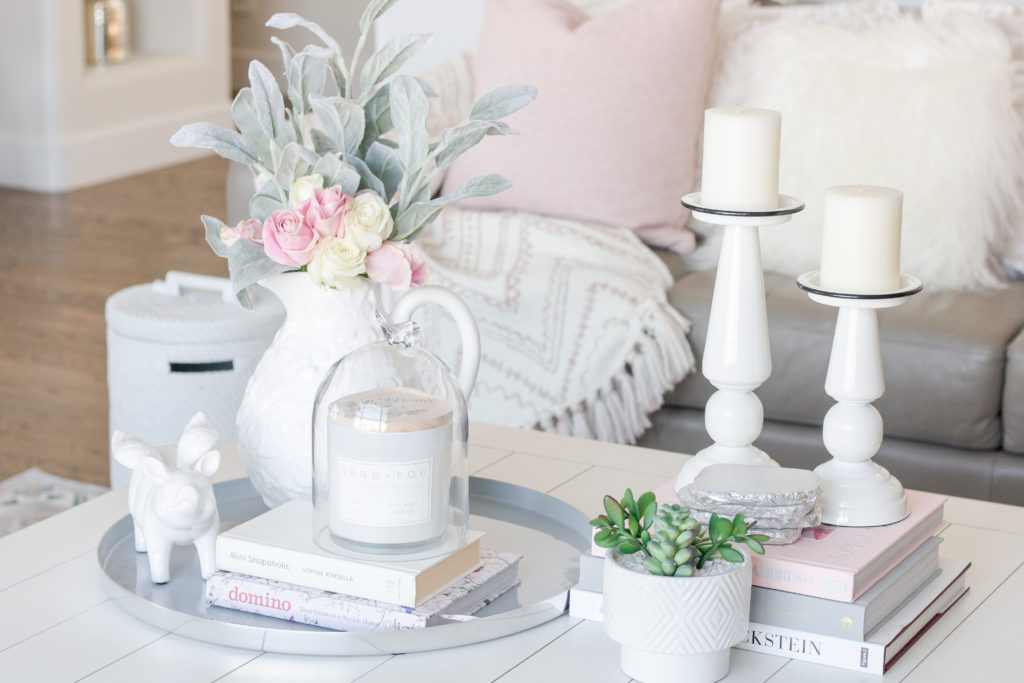 White coffee table styled with a lilac tray, vase full of roses and candle: Pastel Living Room Decor