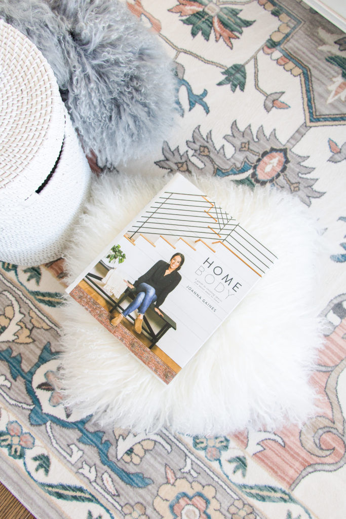 Home Body by Joanna Gaines book styled on a pastel oriental rug with a mongolian sheepskin pillow: Pastel Living Room Decor