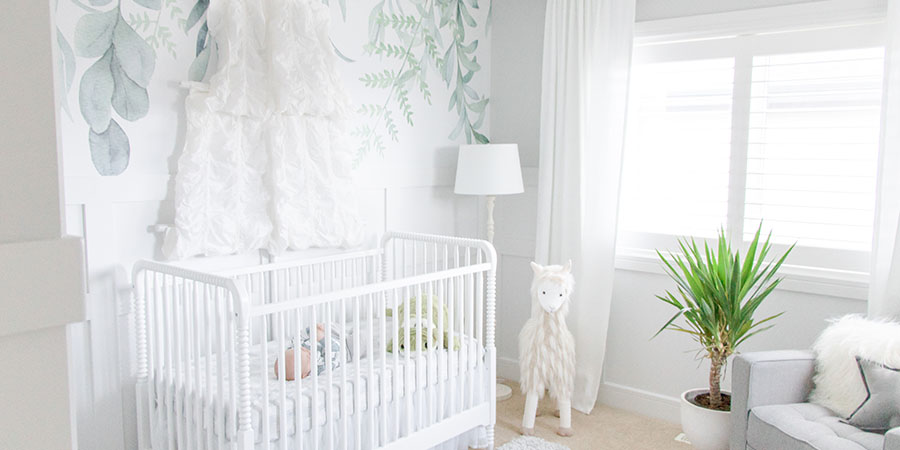 Light and airy nursery with green vine wallpaper