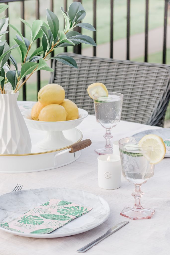 Closeup of outdoor tablescape featuring lemons as decor and as part of beverage
