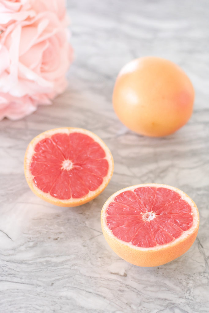 Closeup shot of grapefruit with roses in background