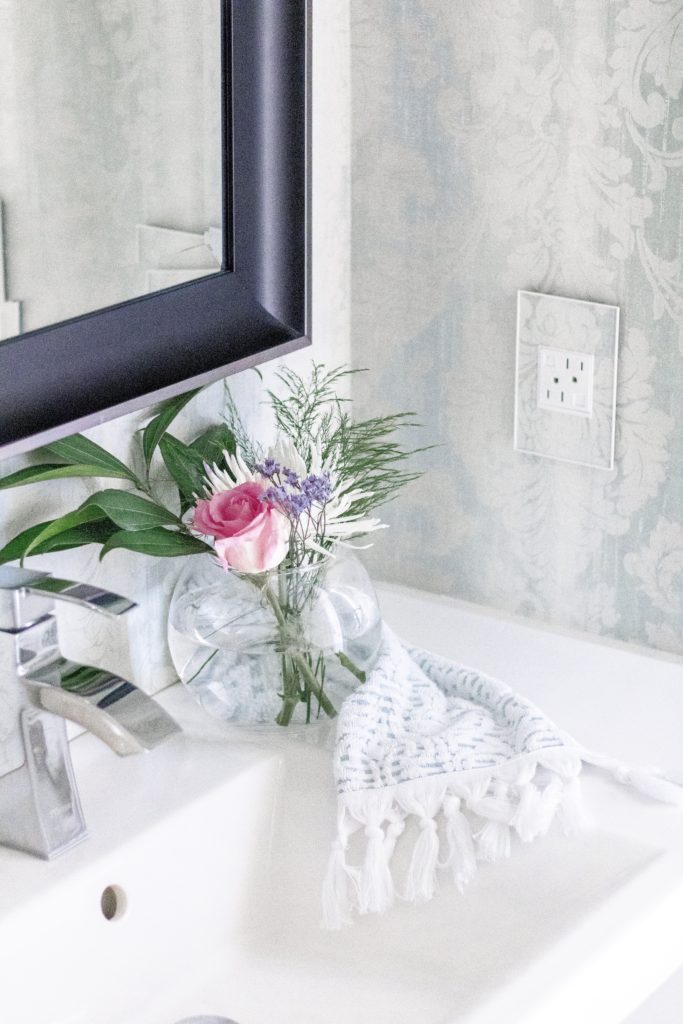 Powder room bathroom with blue patterned wallpaper and matching custom wall plates
