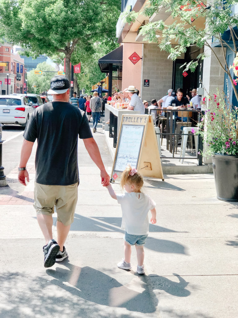 Dad and daughter strolling down 17 ave in Calgary