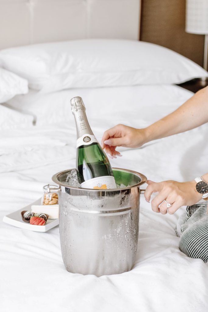 Champagne bucket with dessert on bed at Sheraton Cavalier Calgary Hotel