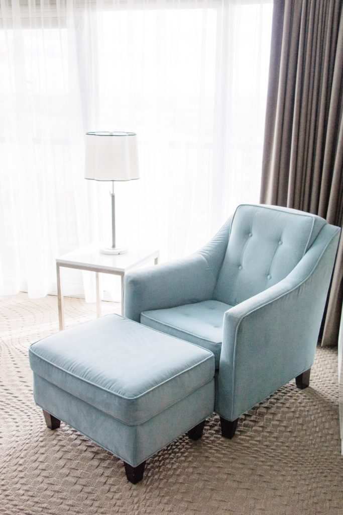 Sitting area with teal armchair at Sheraton Cavalier Calgary Hotel