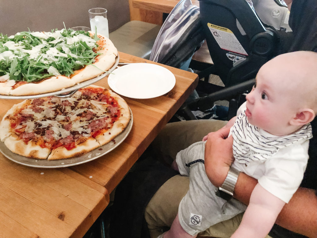 Baby looking at pizza in Calgary