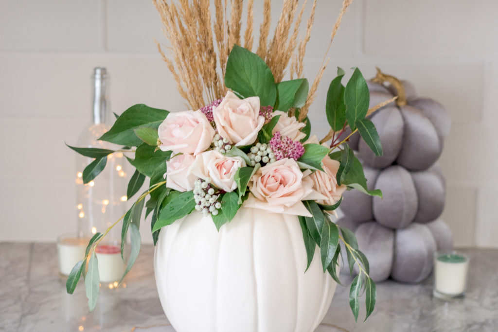 Closeup of greenery and flowers in a white DIY pumpkin vase