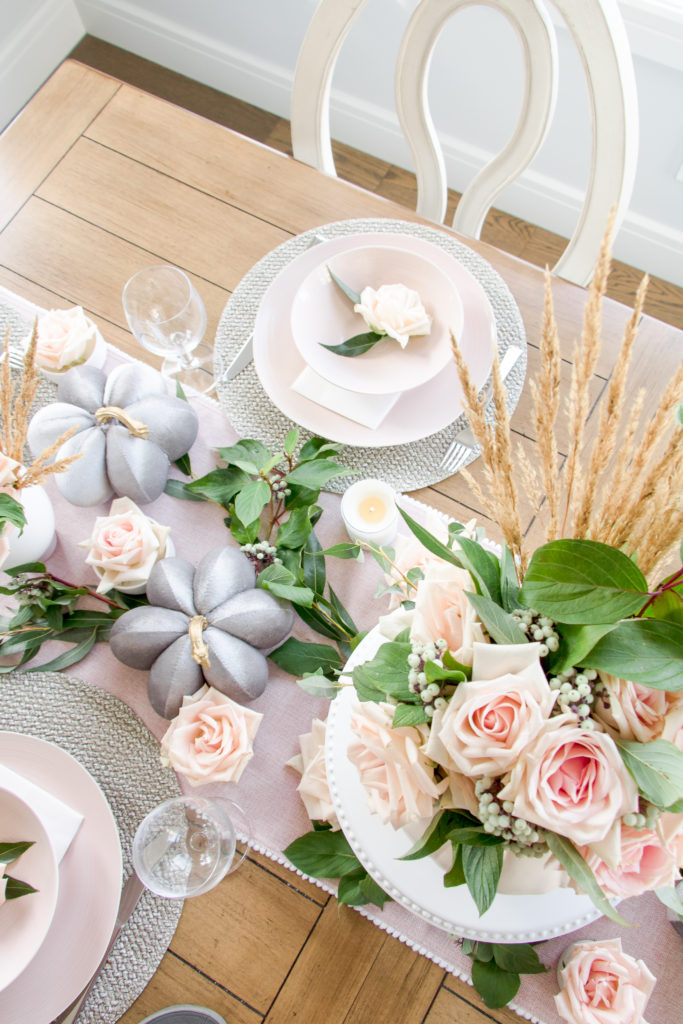 Overhead view of blush pink and gray fall tablescape with fresh greenery
