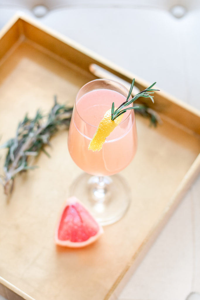Overhead view of Redheaded French Blonde cocktail with lemon rind, fresh grapefruit and rosemary