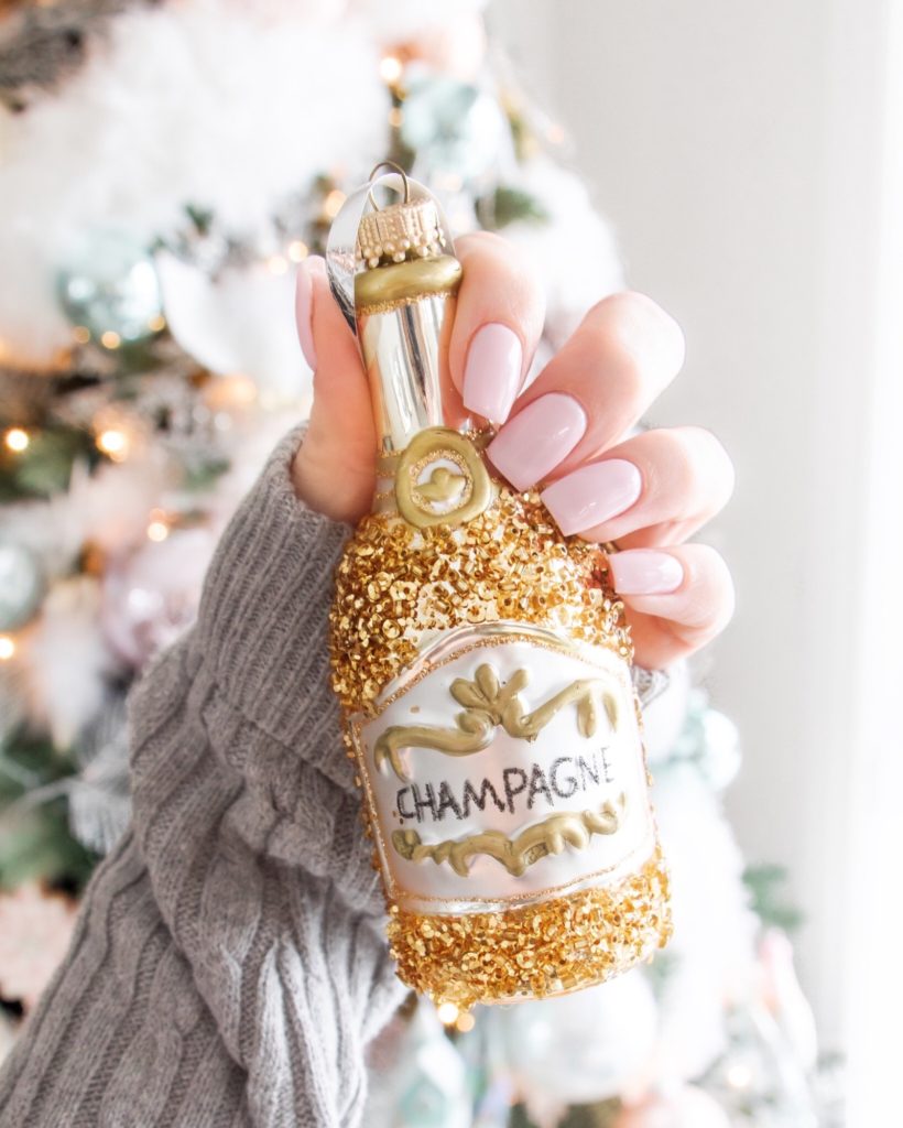 Christmas nail inspo with champagne Christmas ornament