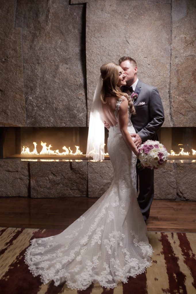 Bride and groom in front of a fireplace