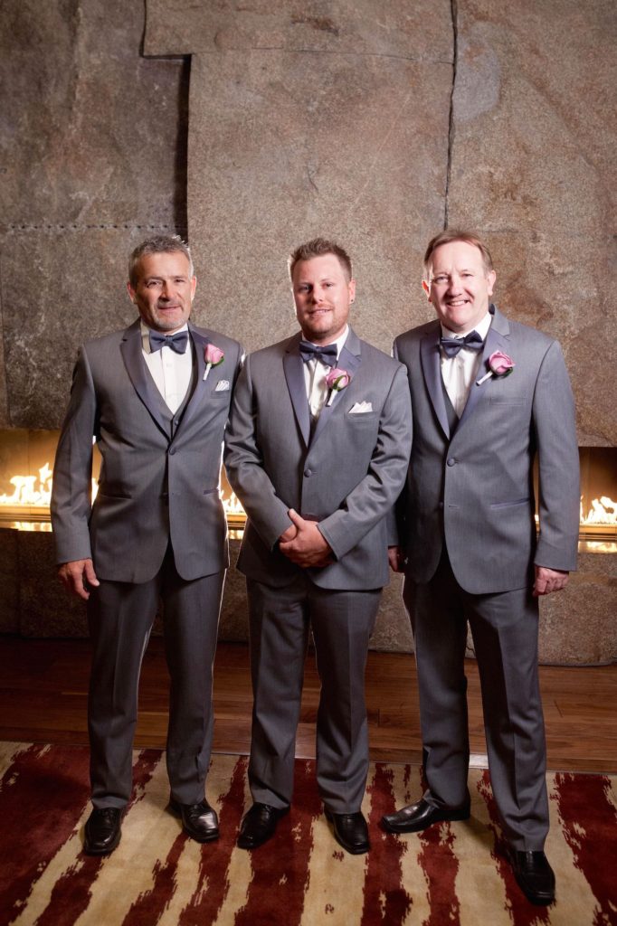 Groom with father and father in law on wedding day