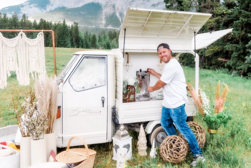 Man pouring champagne from mobile wedding truck 