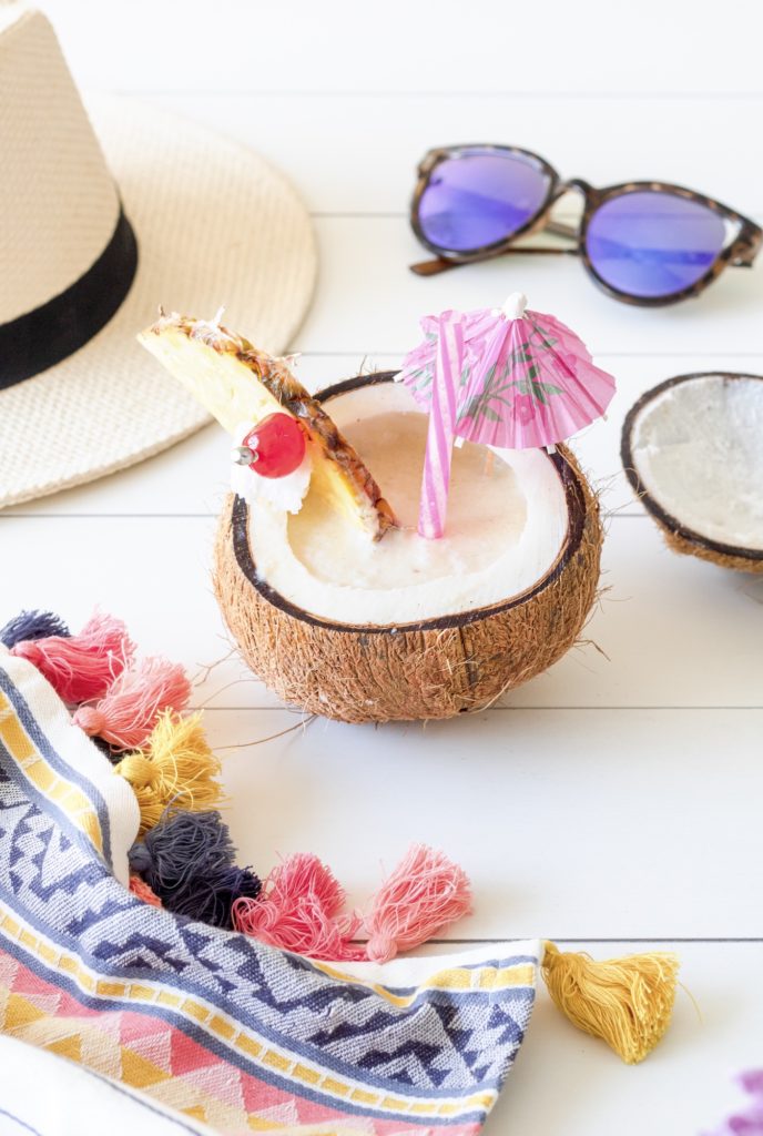 Classic Piña Colada in a coconut cup with a pineapple wedge