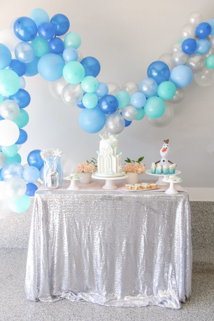 Frozen birthday party dessert table with balloon garland