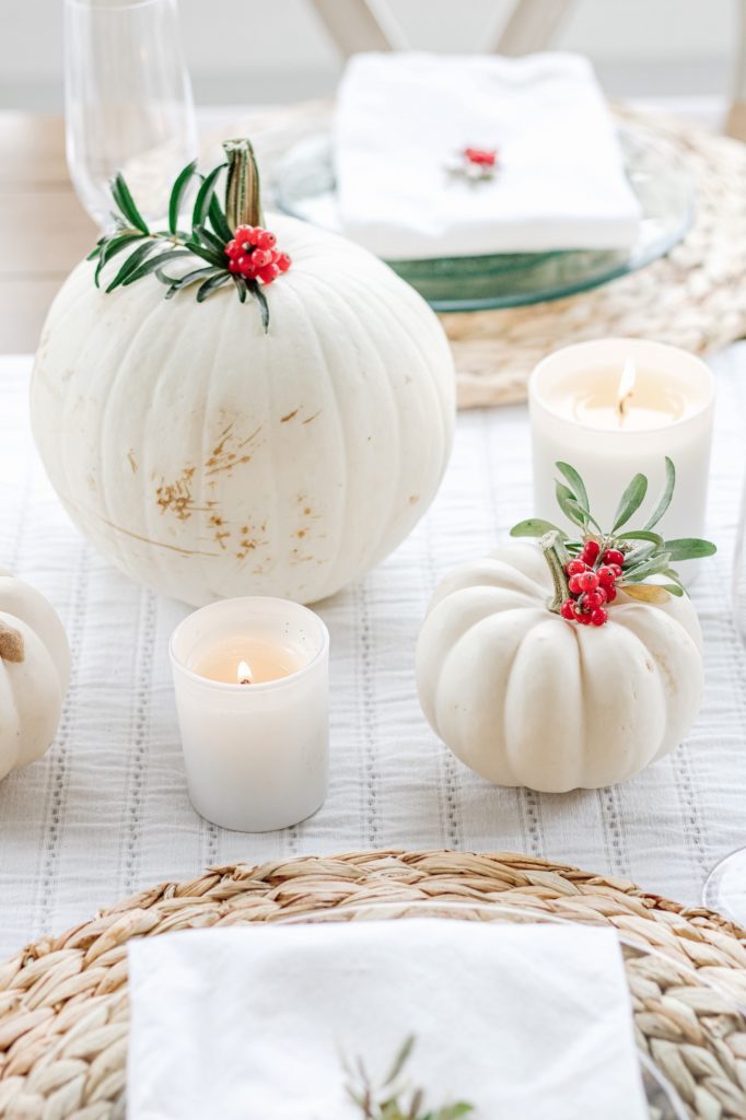 White pumpkin and berry fall tablescape with wood placemats