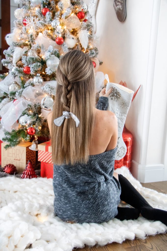 Blogger in front of Christmas tree holding stocking