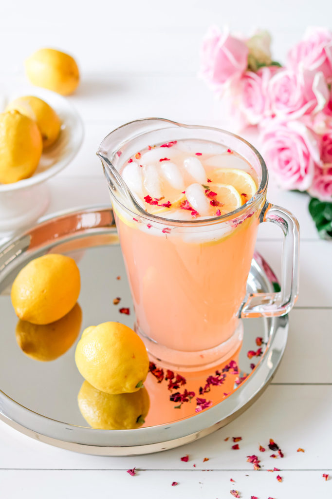 Pitcher of fresh rose lemonade with fresh squeezed lemons and rose petals